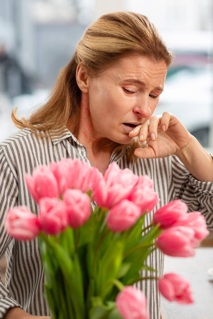 Ama de casa vistiendo camisa rayada estornudando después de recibir ramo
 - Foto, imagen