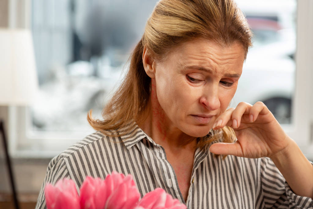Rijpe vrouw gevoel ziek en allergisch voor de bloem bloesem - Foto, afbeelding