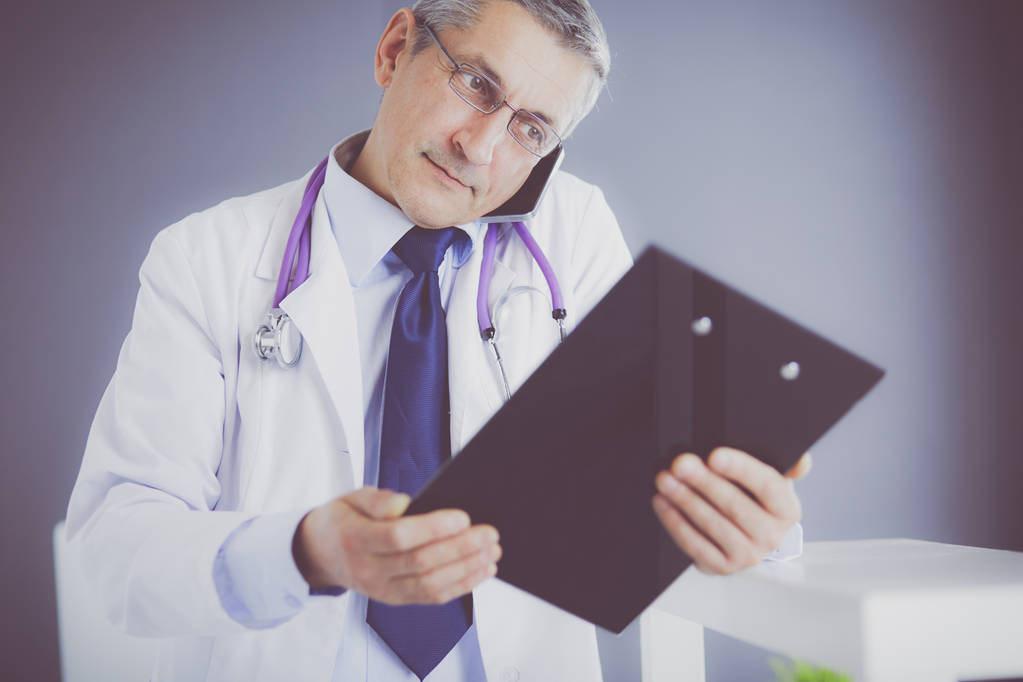 mężczyzna lekarz pisze notatki na schowku w szpitalu - Zdjęcie, obraz