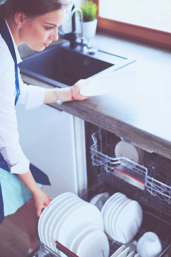 Spülmaschine. Junge Frau in der Küche bei der Hausarbeit. Abwasch - Foto, Bild