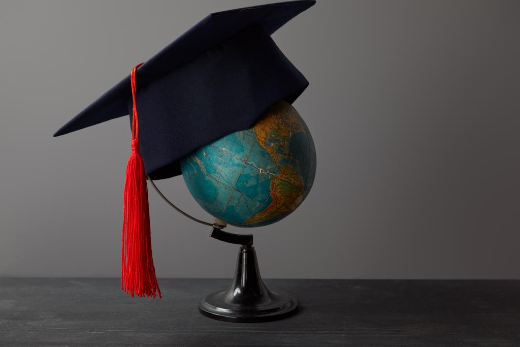Casquette académique avec pompon rouge sur le globe à la surface sombre
 - Photo, image