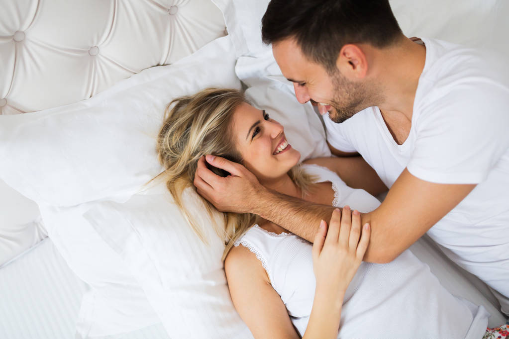 Joven pareja feliz teniendo momentos románticos en el dormitorio
 - Foto, Imagen