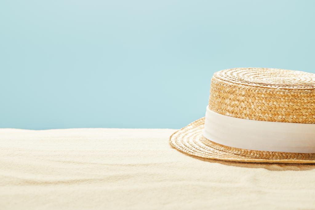 focalizzazione selettiva del cappello di paglia sulla spiaggia sabbiosa in estate isolato sul blu
 - Foto, immagini