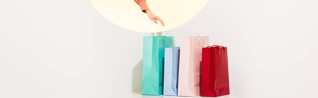 plano panorámico de chica y coloridas bolsas de compras en blanco con círculo amarillo y espacio de copia
 - Foto, Imagen