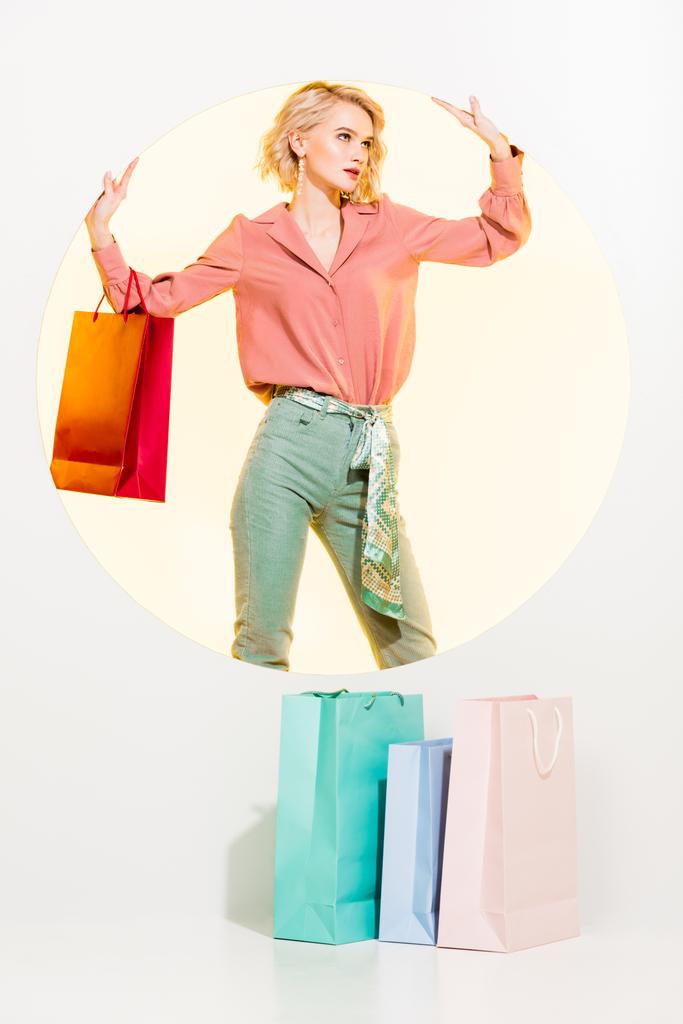 bela menina elegante com sacos de compras posando no branco com círculo amarelo
 - Foto, Imagem