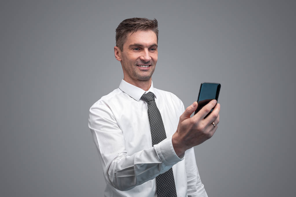 Hombre de negocios sonriente usando teléfono inteligente - Foto, Imagen