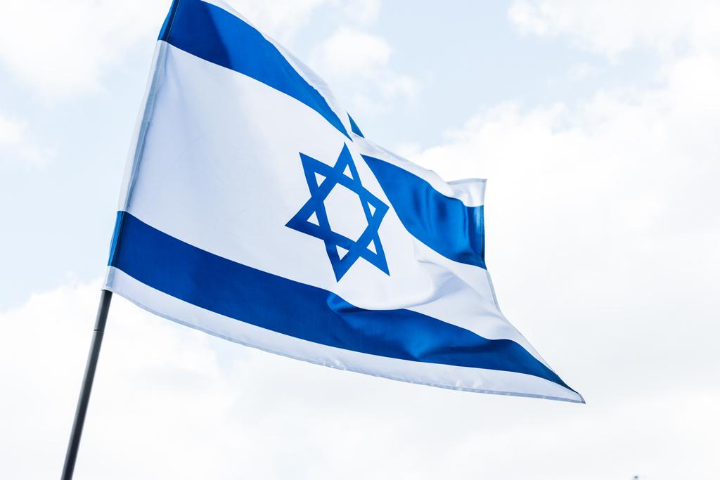 Izrael nemzeti zászlaja alacsony látószögű nézet, Dávid sztárja ellen, felhők   - Fotó, kép