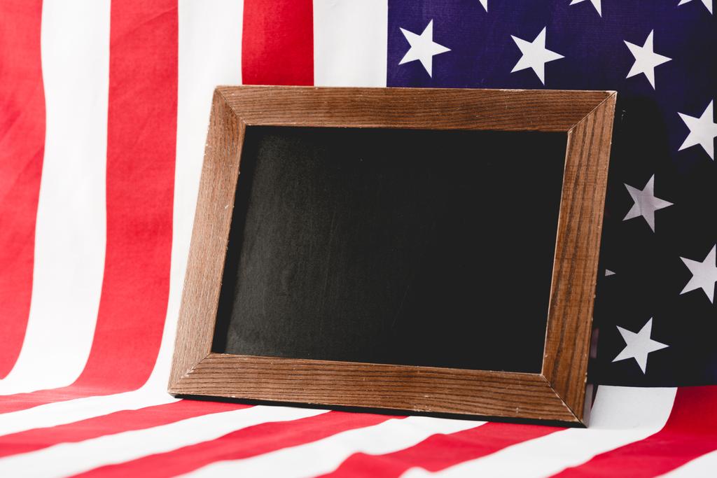 placa preta vazia perto da bandeira americana com estrelas e listras
 - Foto, Imagem