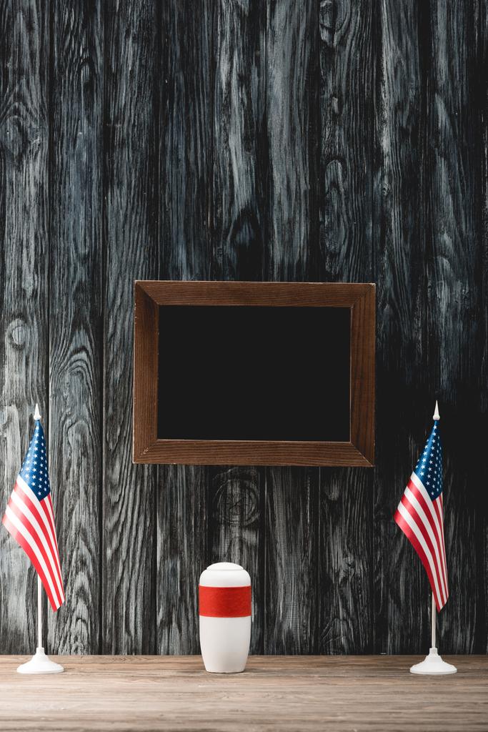külleri ve Amerikan bayrakları ile cenaze urn yakın boş siyah tahta - Fotoğraf, Görsel