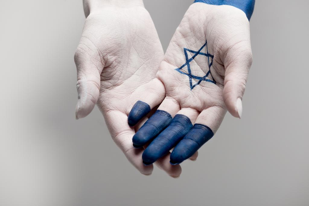 обрізаний вид рук з блакитною зіркою Девіда на сірому
 - Фото, зображення