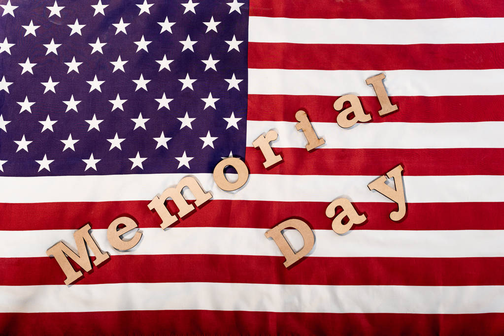 top view of memorial day lettering on american flag with stars and stripes  - Photo, Image