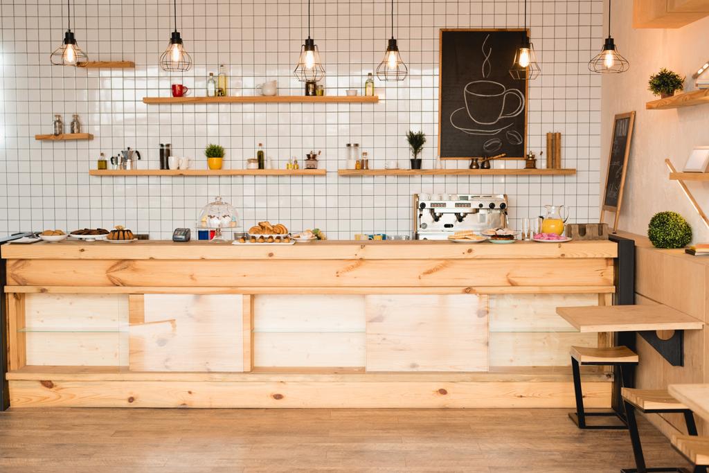 interior of cafeteria with wooden bar counter, shelves and board with drawn coffee cup - Photo, Image
