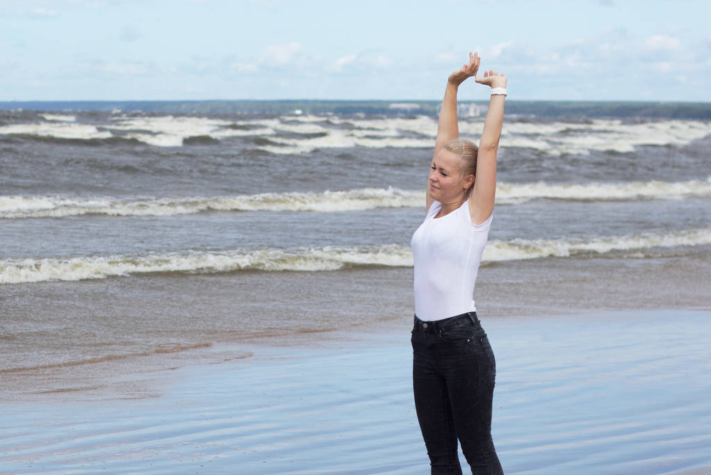 щаслива дівчина на пляжі в білій футболці, затока
 - Фото, зображення