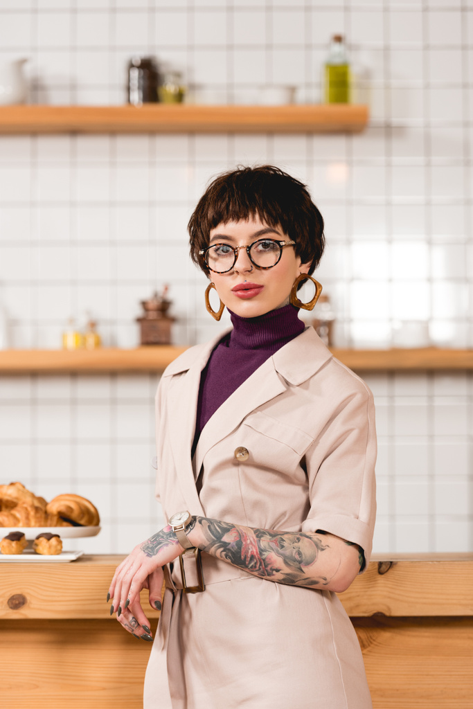 trendy, attractive businesswoman standing near bar counter in cafeteria - Photo, Image