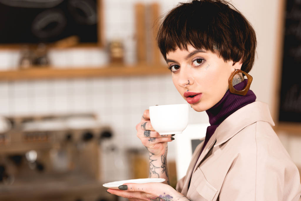 bonita mujer de negocios bebiendo café y mirando a la cámara en la cafetería
 - Foto, imagen