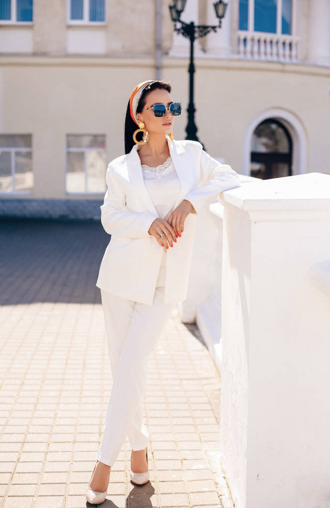 krásná žena s tmavými vlasy v elegantním bílém obleku a doplňk - Fotografie, Obrázek