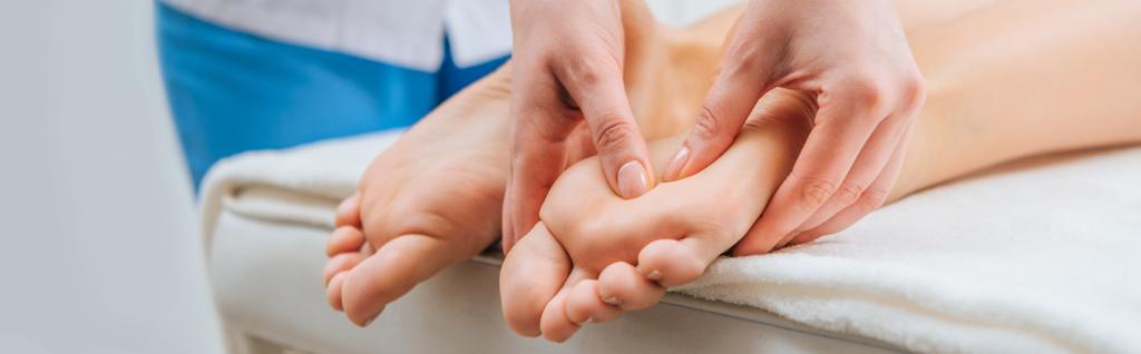 Vue panoramique de masseur faisant massage des pieds à la femme sur la table de massage
 - Photo, image