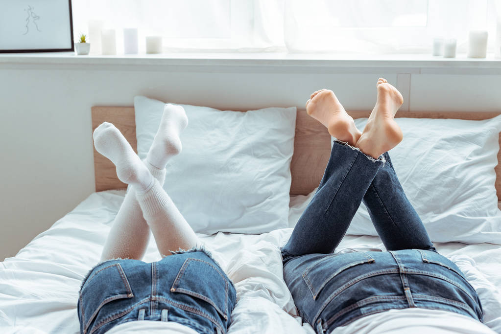 vista recortada de hombre y mujer en jeans y pantalones cortos en el dormitorio
  - Foto, Imagen
