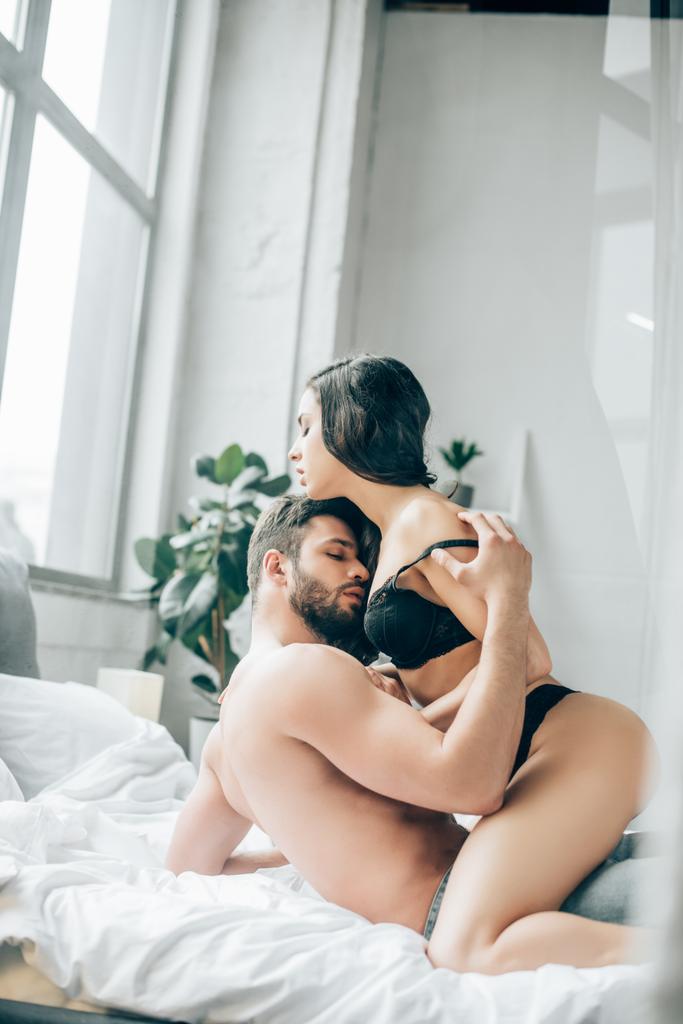 homme passionné embrasser et déshabiller fille brune sur le lit
  - Photo, image
