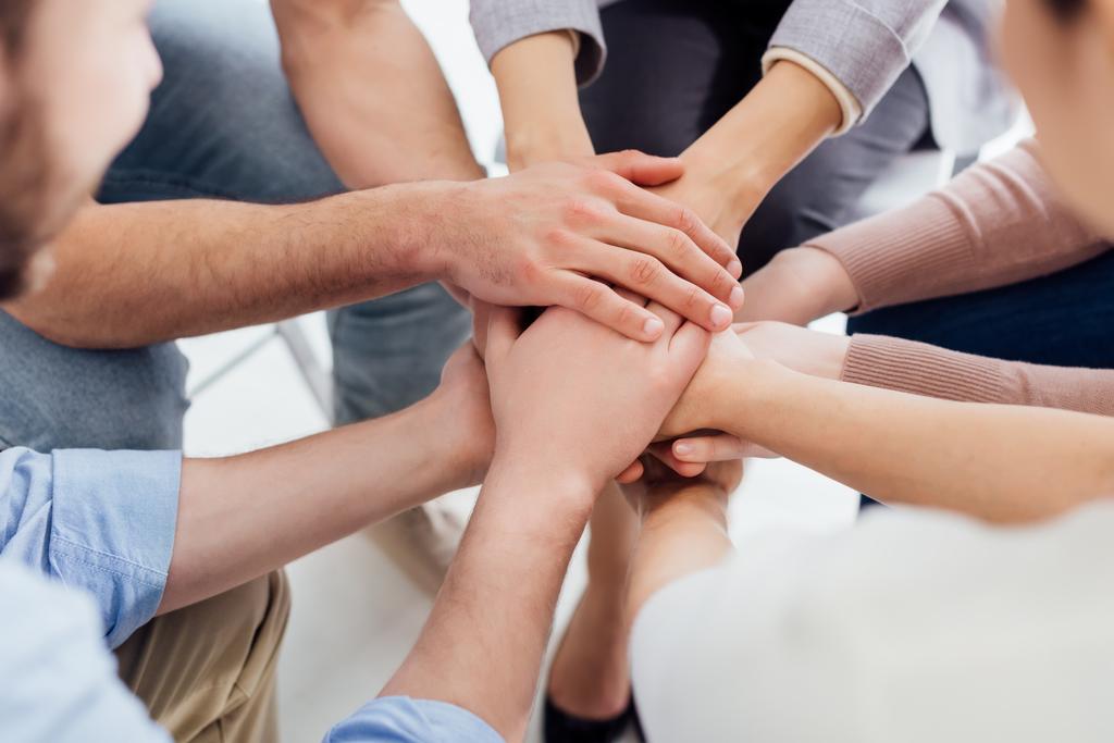 cropped view of people stacking hands during group therapy session  - Photo, Image