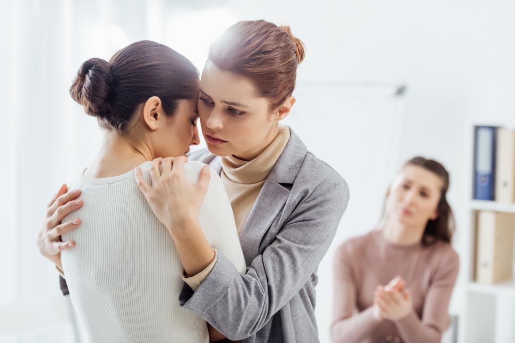 Selektivní fokus ženy objímat jinou ženu během terapie setkání - Fotografie, Obrázek