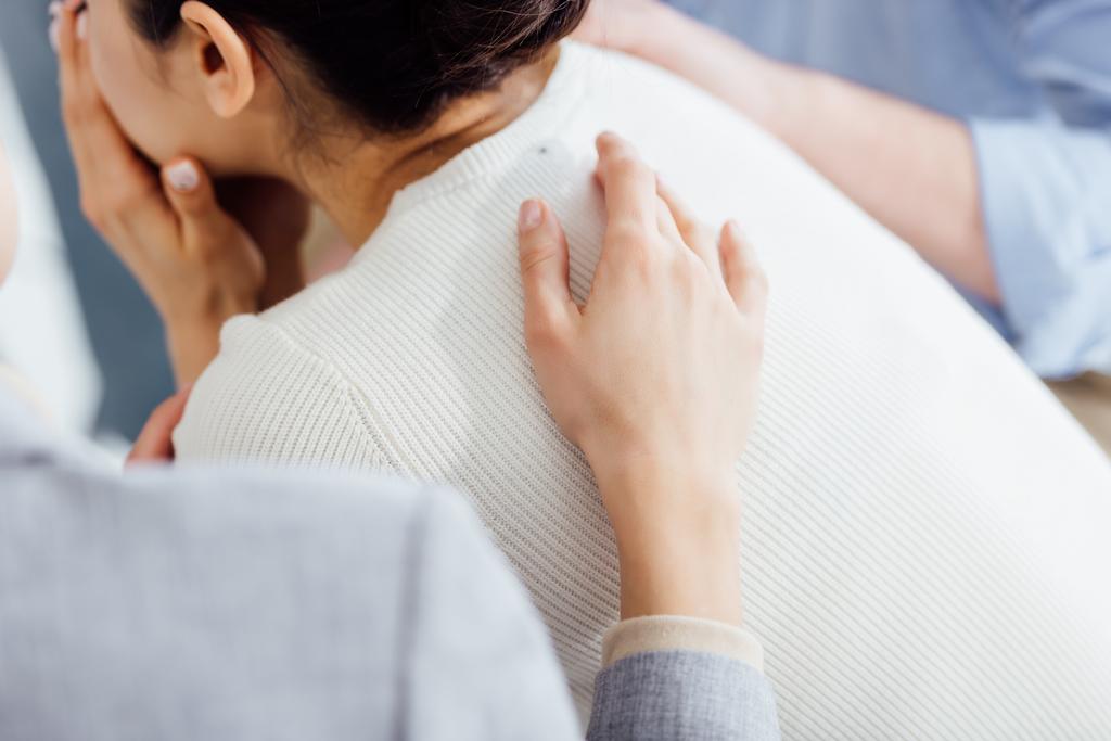 Ausgeschnittene Ansicht einer Frau, die eine andere Frau während eines Therapiegesprächs tröstet - Foto, Bild