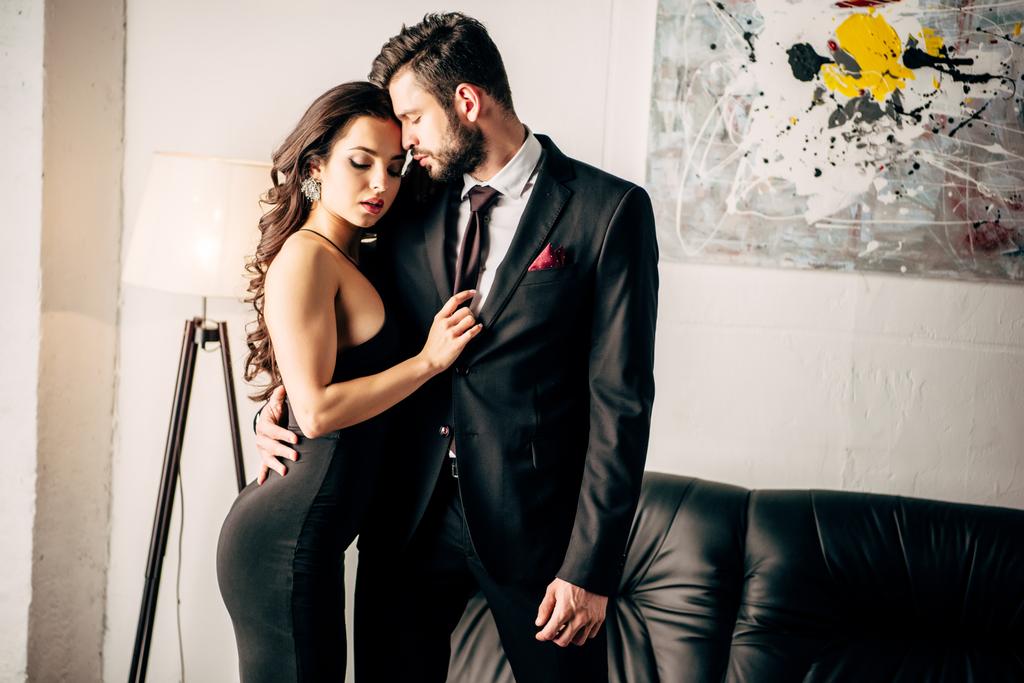 man in suit standing with attractive woman in black dress  - Photo, Image