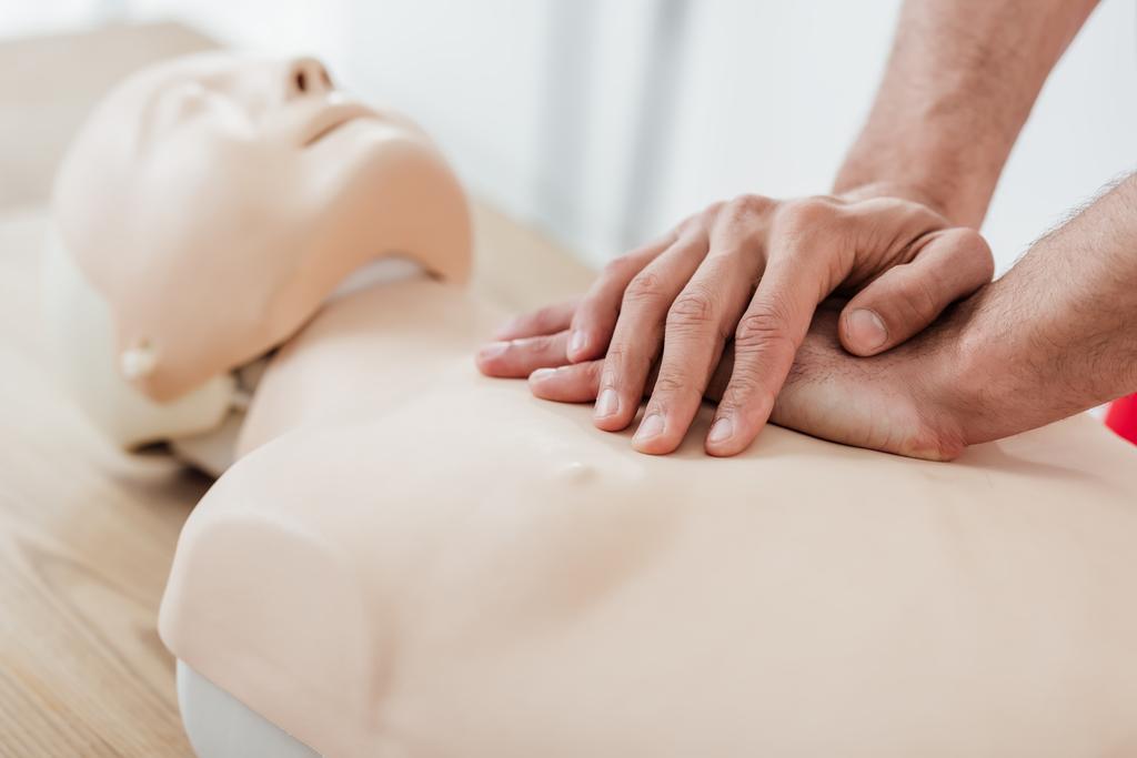 Ausgeschnittene Ansicht eines Mannes mit Brustkompressionstechnik am Dummy während des CPR-Trainings  - Foto, Bild