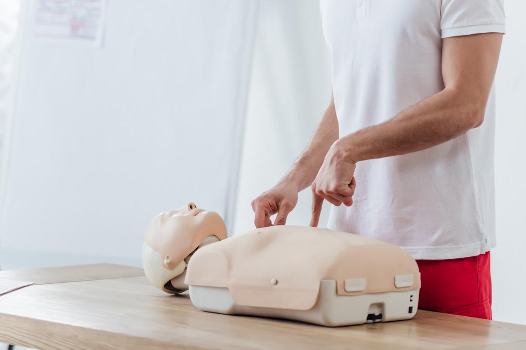 cropped view of man pointing with finger at dummy while practicing cpr during first aid training - Photo, Image