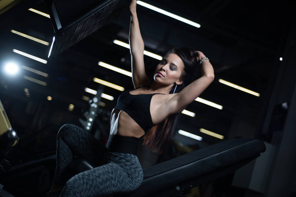 Фітнес дівчина позує в спортзалі, показує її тіло і розслабляється після тренування
 - Фото, зображення