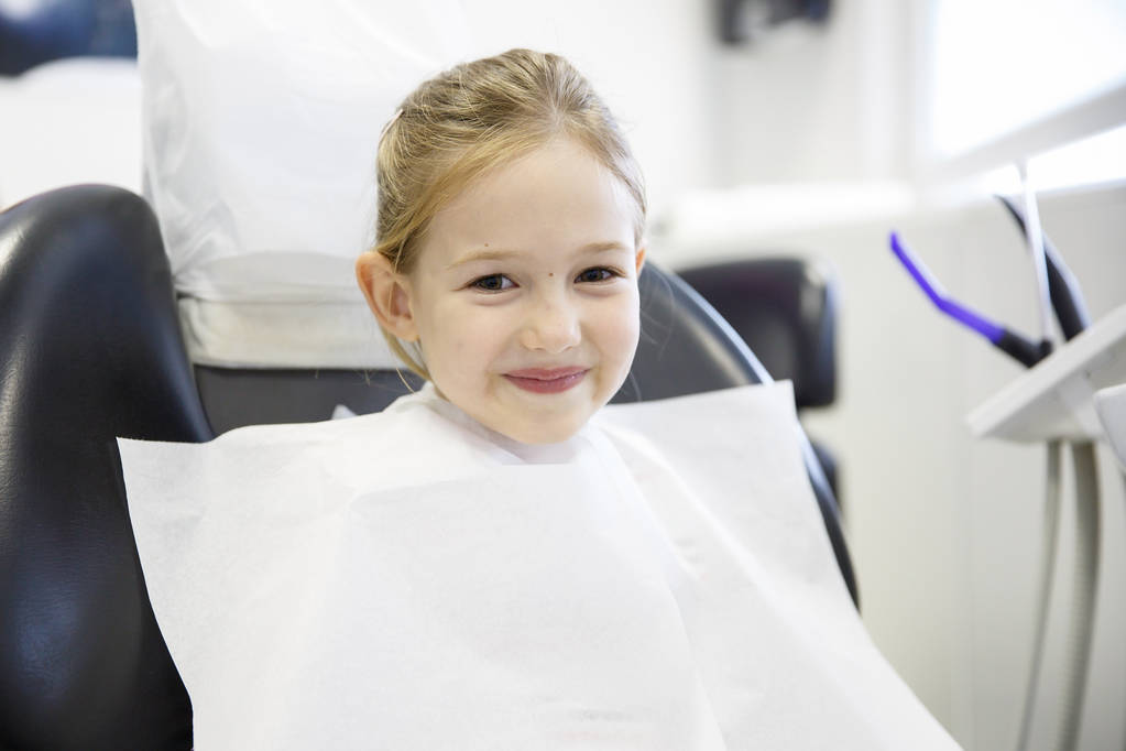 Uśmiechnięta dziewczynka w gabinecie stomatologicznym.  - Zdjęcie, obraz