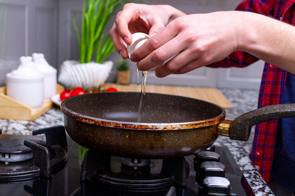 Freír caseros, huevos de pollo en la sartén en la cocina en casa. Cocinar un desayuno saludable con proteínas
.  - Foto, Imagen