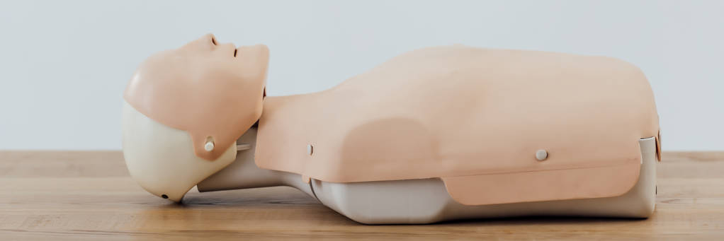 panoramic shot of cpr dummy for first aid training on wooden table  - Photo, Image