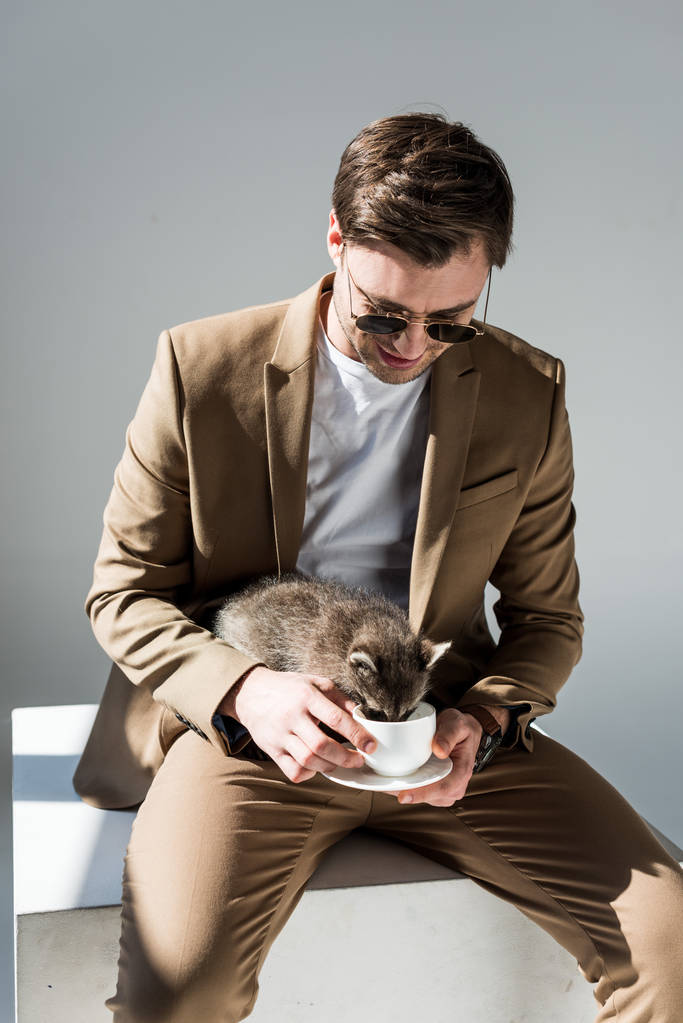 Smiling Man Holding Funny Raccoon Drinking From Free Stock Photo and Image
