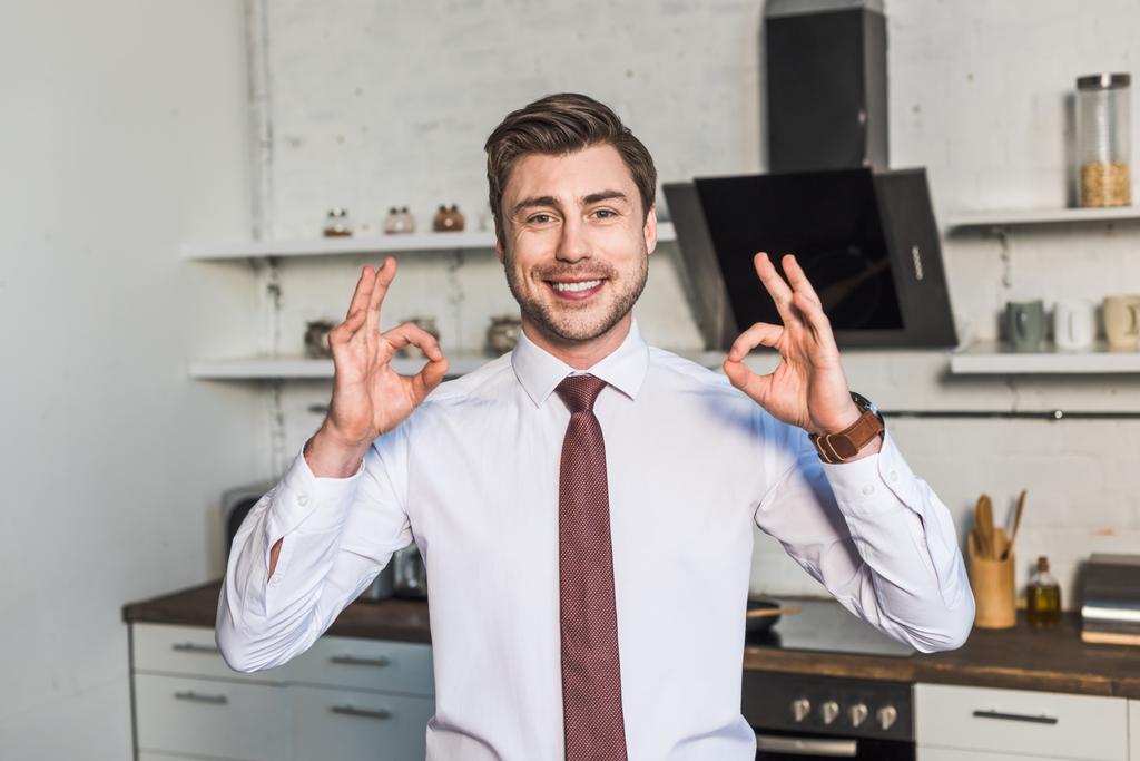 cheerful man standing in kitchen at home and showing ok signs - Photo, Image
