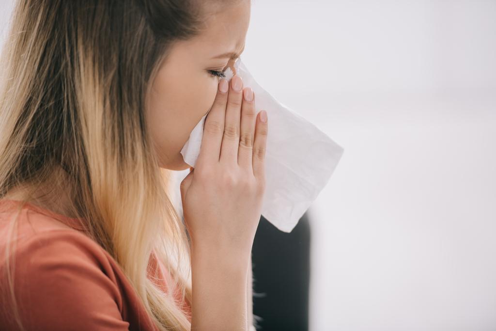 primer plano de mujer rubia estornudando en tejido blanco
  - Foto, imagen