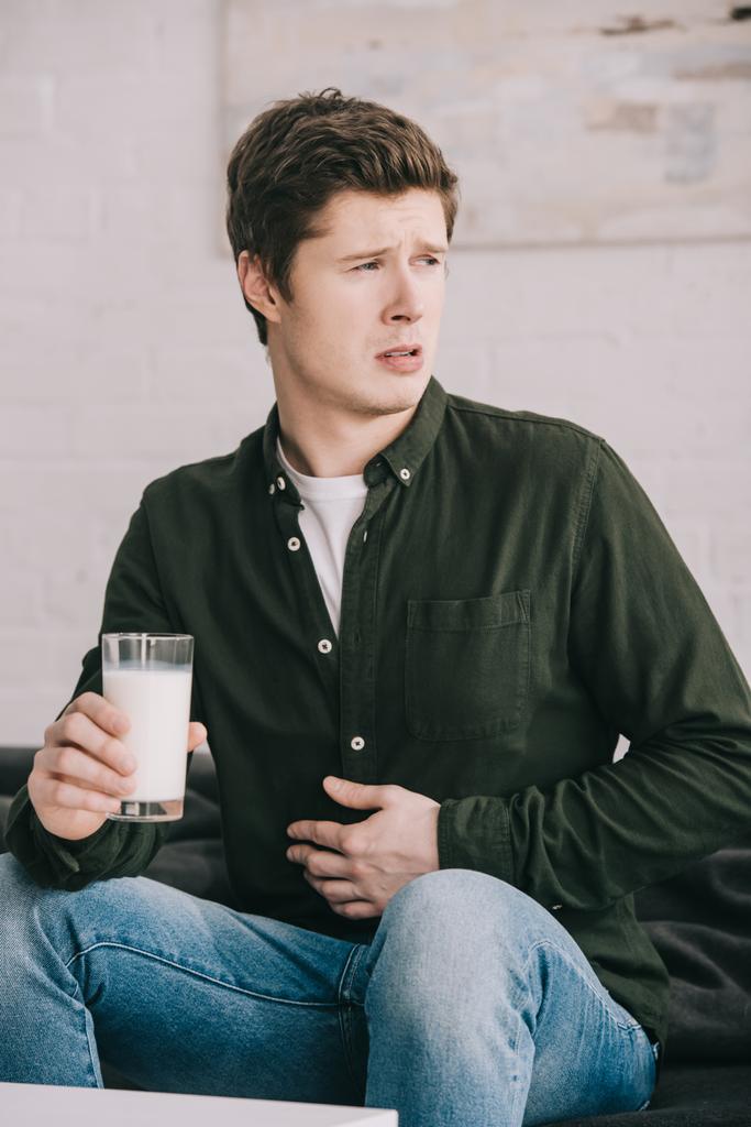 guapo molesto hombre con vaso de leche celebración estómago
  - Foto, Imagen