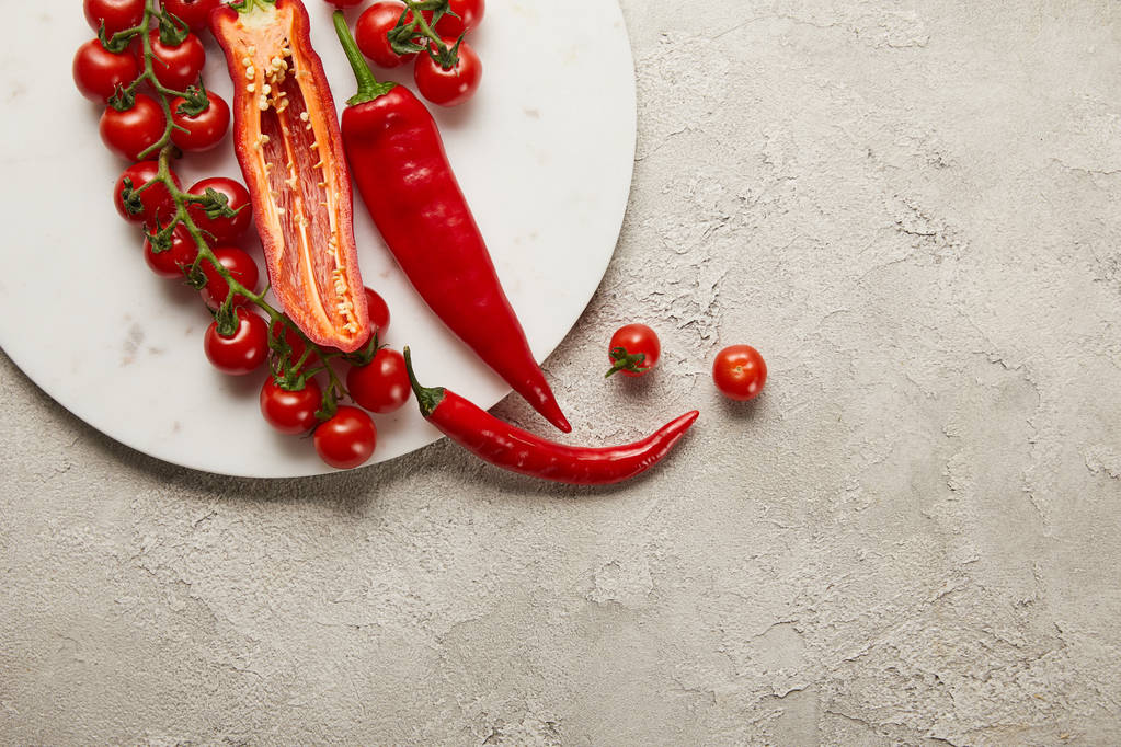 Вид зверху на перець чилі, вишневі помідори та квасоля на текстурованій поверхні
 - Фото, зображення