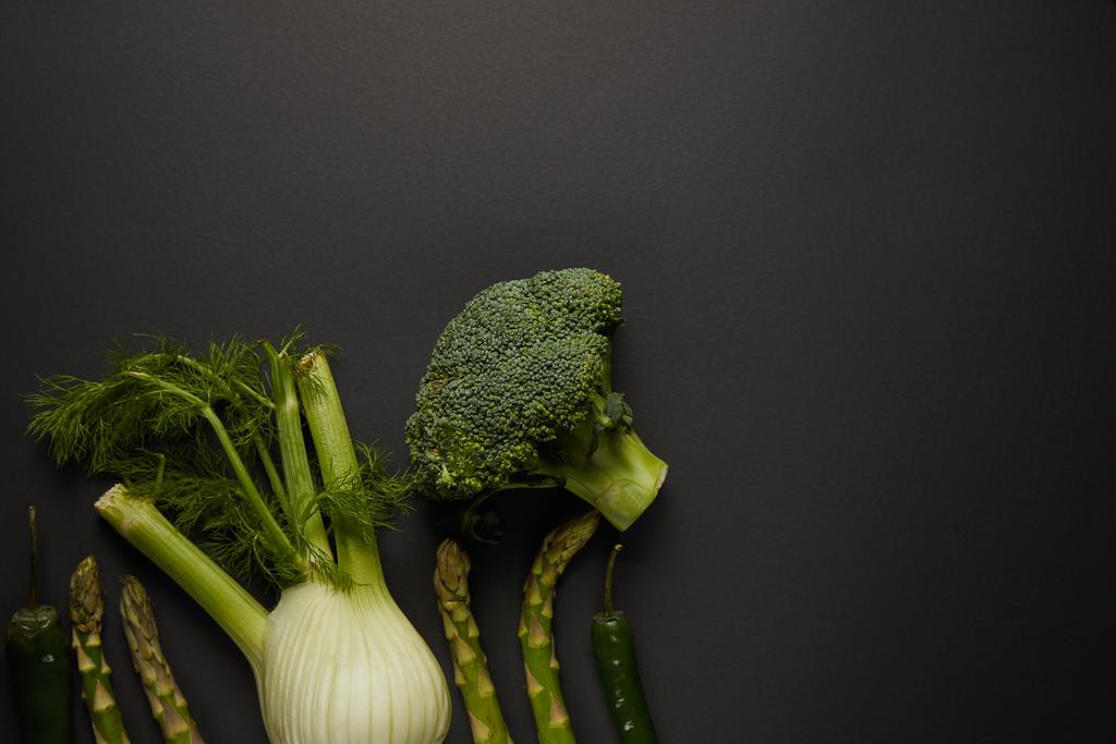 Draufsicht auf frisches grünes Gemüse auf schwarzer Oberfläche - Foto, Bild