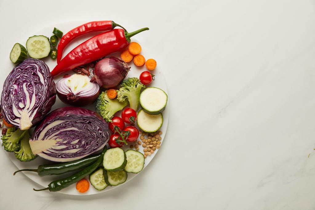 Vue de dessus des légumes entiers et coupés sur la surface blanche
 - Photo, image