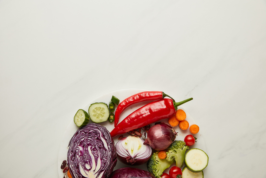 Top näkymä tuoretta leikata ja kokonaisia vihanneksia valkoisella pinnalla
 - Valokuva, kuva