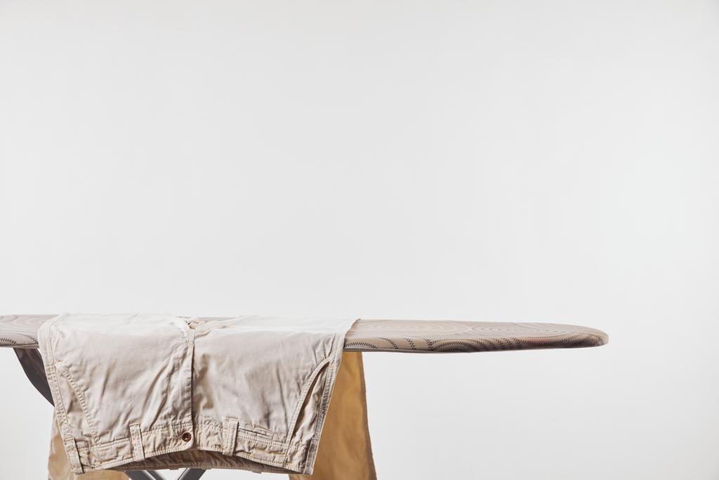 Bézs férfi nadrág a vasalódeszka izolált szürke - Fotó, kép
