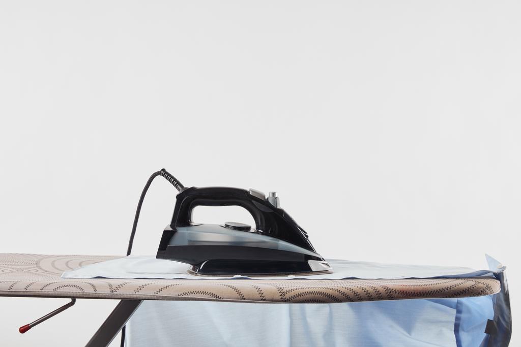 Camisa de ferro e azul na tábua de engomar isolada em branco
 - Foto, Imagem