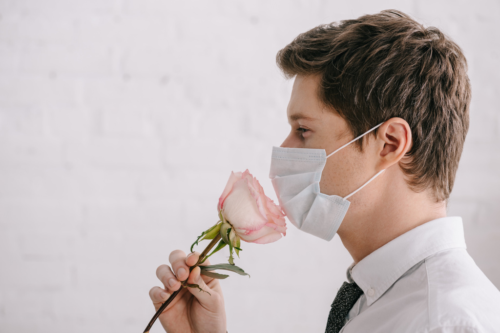 vista laterale dell'uomo con allergia al polline in maschera medica odore rosa
  - Foto, immagini