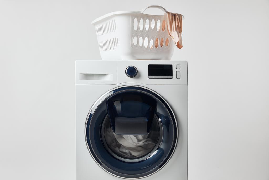 Gri üzerinde izole çamaşır sepeti ile yıkama makinesi - Fotoğraf, Görsel
