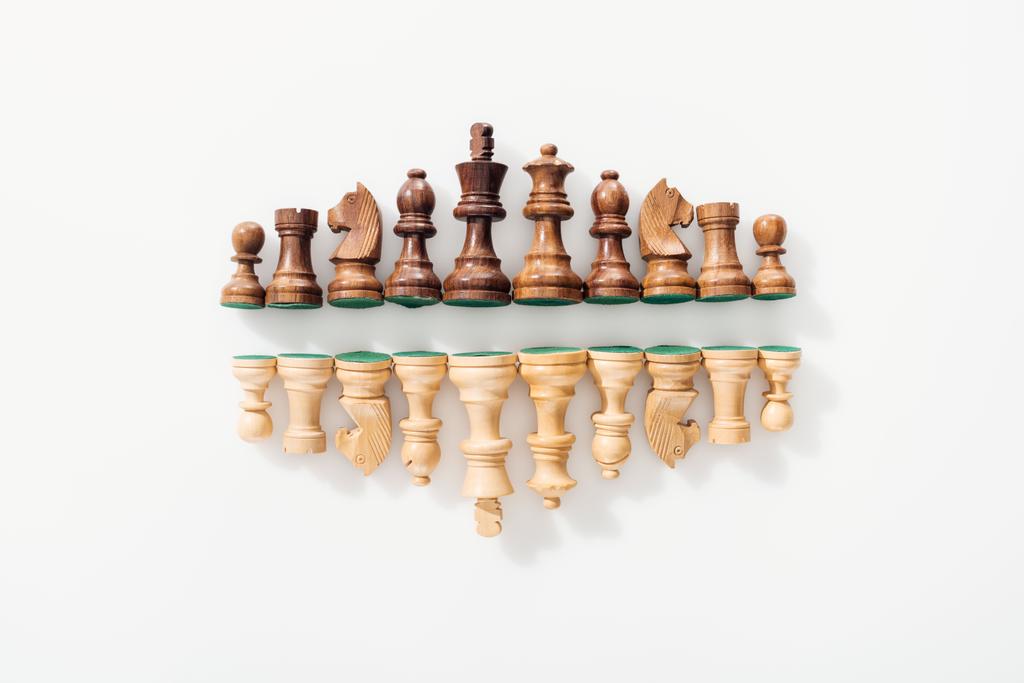 top view of rows made of brown and beige wooden chess figures on white background - Photo, Image