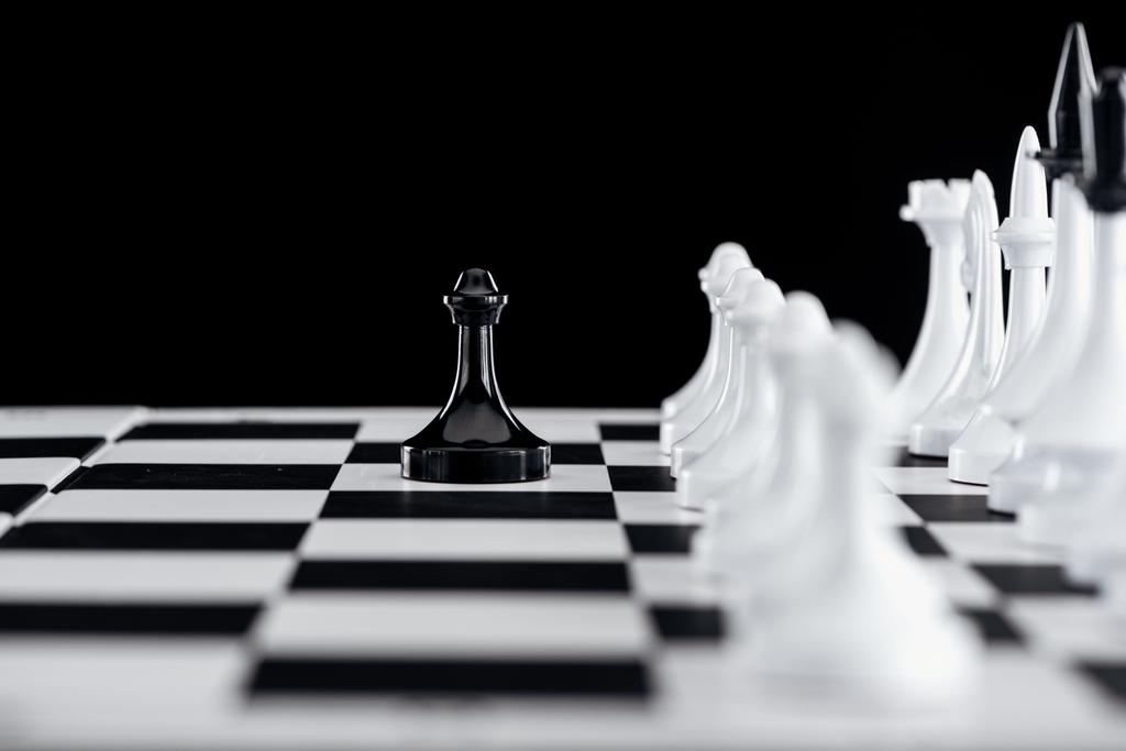 селективный фокус шахматной доски с белыми шахматными фигурами и черной пешкой спереди изолирован на черном
 - Фото, изображение