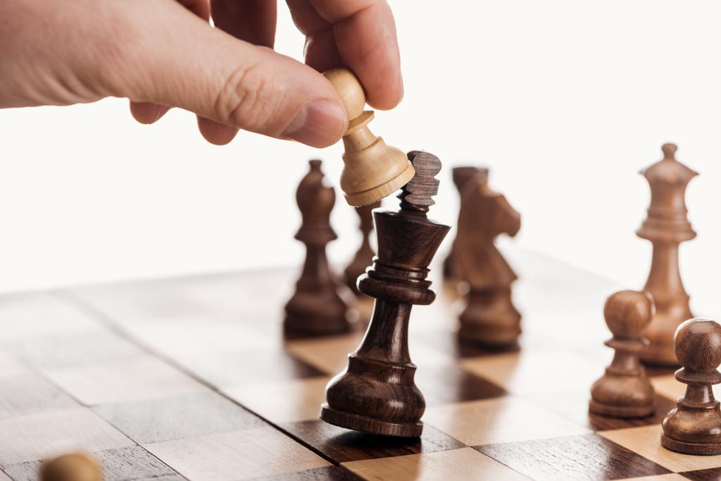 gedeeltelijke weergave van man met pion boven houten schaakbord geïsoleerd op wit - Foto, afbeelding