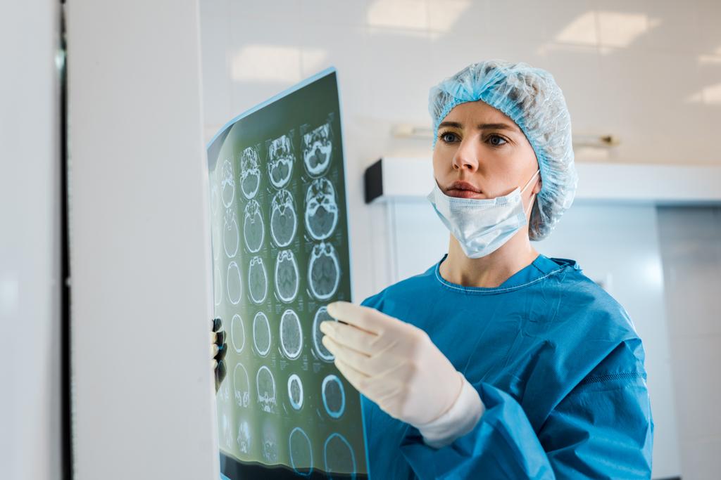 atractivo médico en gorra médica y uniforme de rayos X de retención en la clínica
  - Foto, Imagen