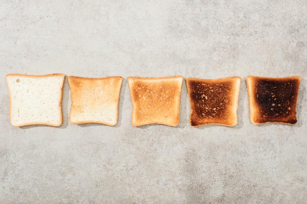 Vista superior de torradas de pão na superfície texturizada cinza
 - Foto, Imagem